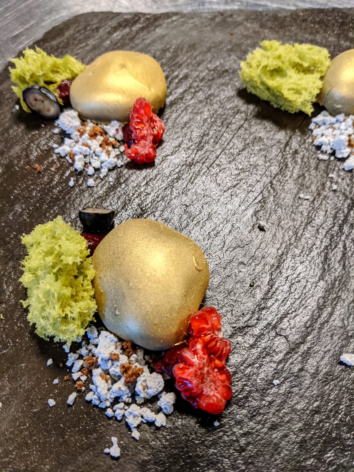 Dessert mit goldener Kugel auf Schieferplatte