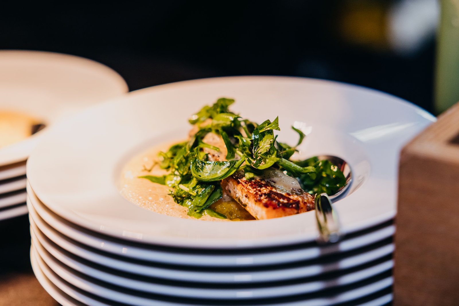 Fischfilet mit grünem Gemüse auf weißem Porzellan