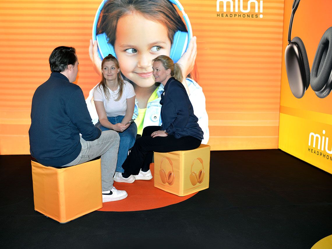 Guests sitting on event cubes in front of a lightbox