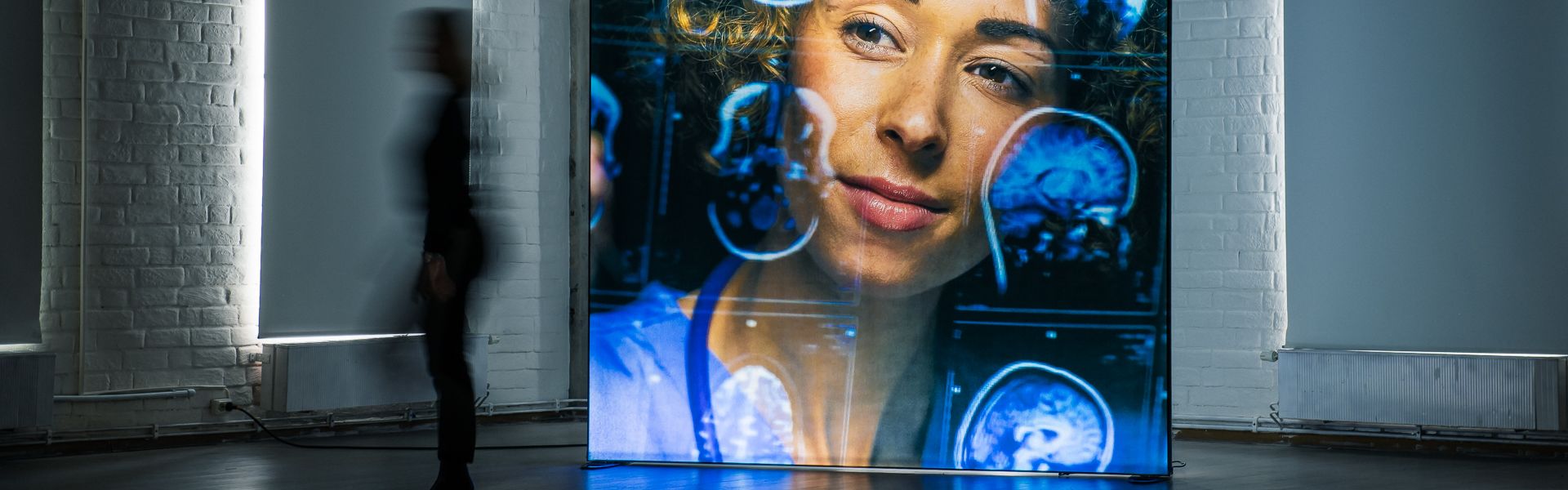 Beleuchteter Messestand mit großformatiger Lightbox in dunkler Halle