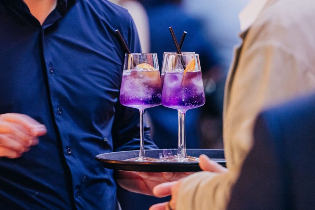 Zwei lilafarbene Cocktails auf einem Serviertablett